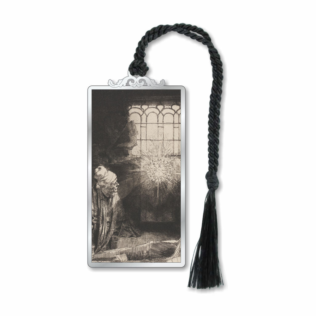 A silver metal bookmark featuring an etching by Rembrandt with a figure and a dramatic lighting effect, attached to a black braided ribbon.