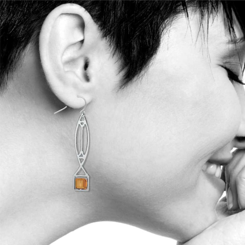 Winslow Lightscreen Earrings, silver-tone elongated geometric earring with amber-orange stained-glass-inspired accents shown on model