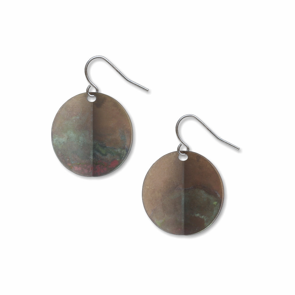 An Orb circular drop earrings with a weathered metallic patina, inspired by Ellsworth Kelly’s sculptural abstract forms and shifting light and shadow