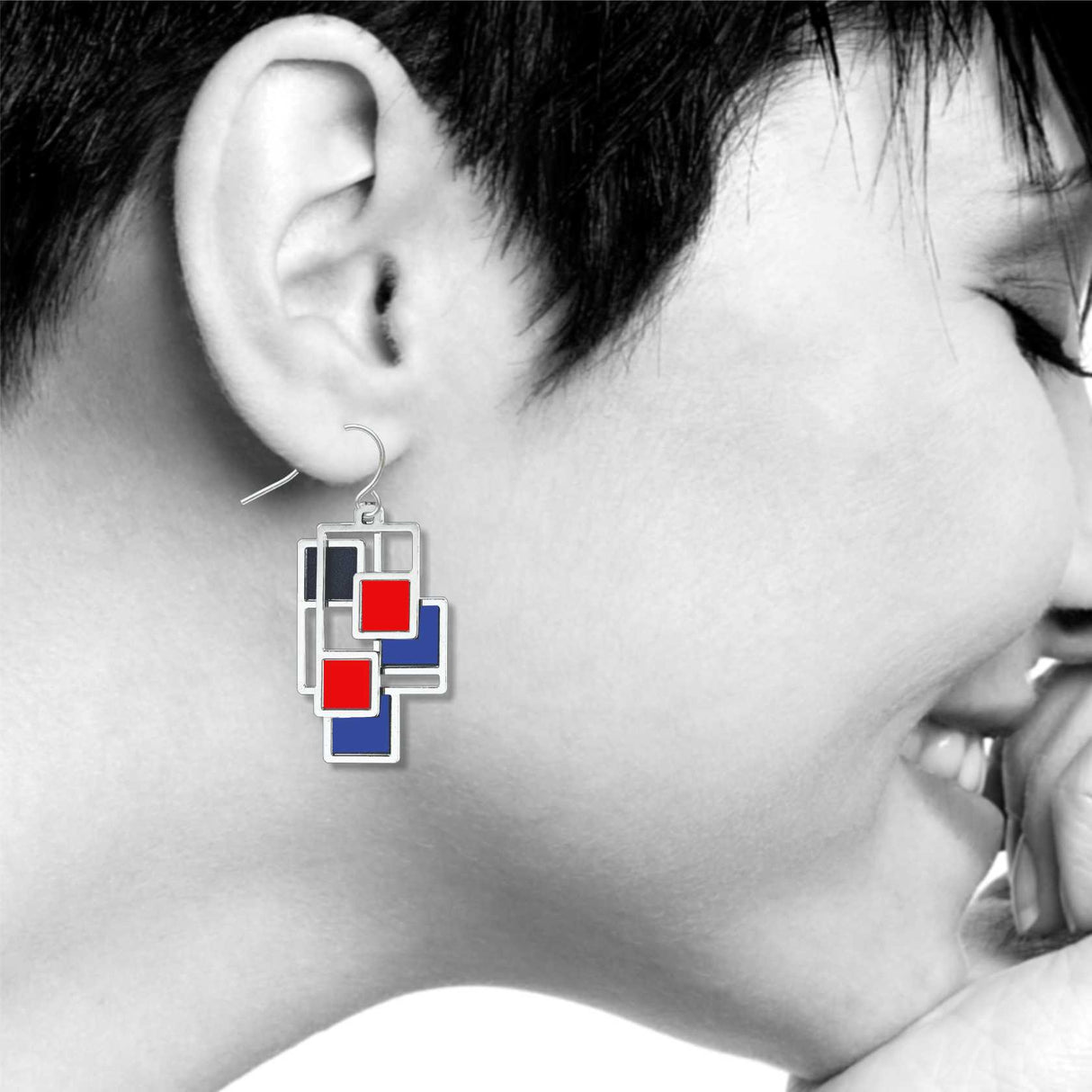 Abstract 1 earrings shown worn, highlighting the geometric Mondrian-inspired design with layered silver-tone shapes and vivid red and blue accents.