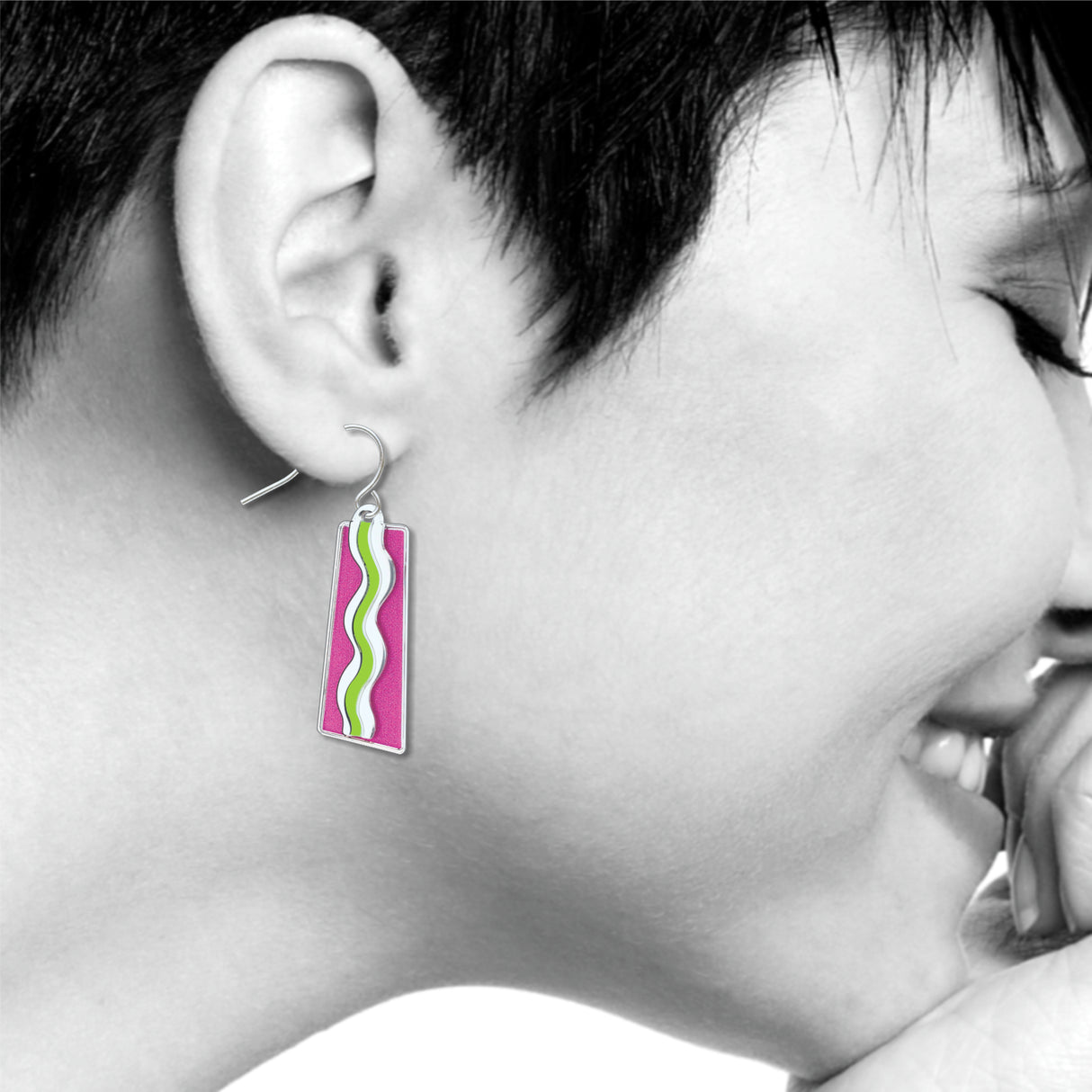 Model wearing a Matisse & the Fauves rectangular drop earring featuring vibrant pink enamel with flowing white and green wave designs inspired by Henri Matisse’s Fauvist artwork.