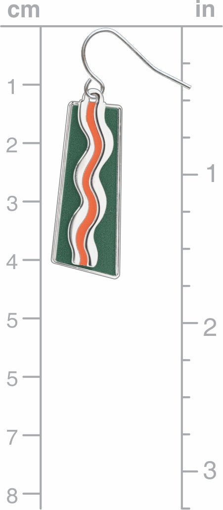 Green enamel drop earring with orange and white wave design and silver hook on a measurement scale