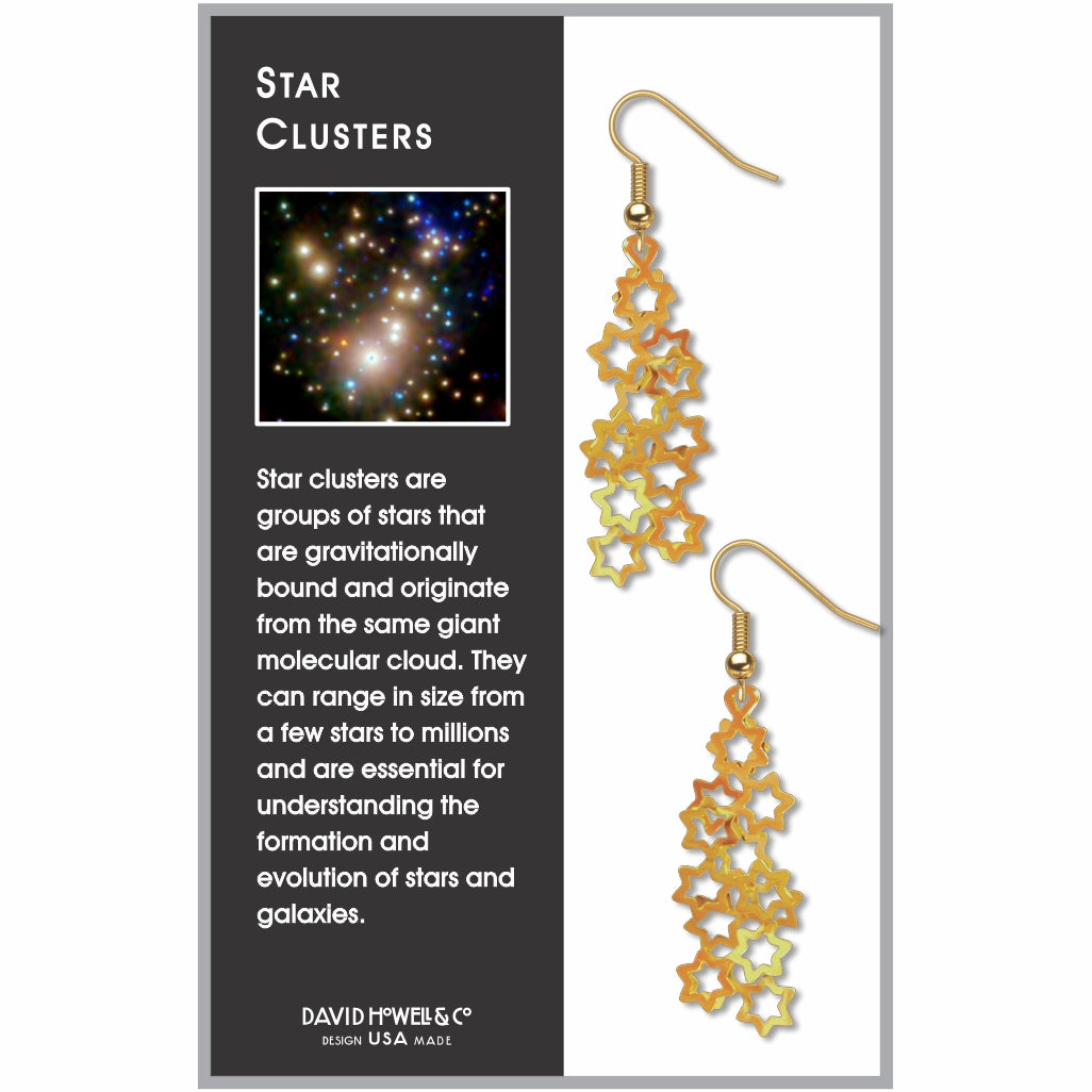 Star Clusters dangling earrings featuring cascading gold-tone open star shapes inspired by astronomical star clusters, displayed on product packaging with a galaxy image and educational description.