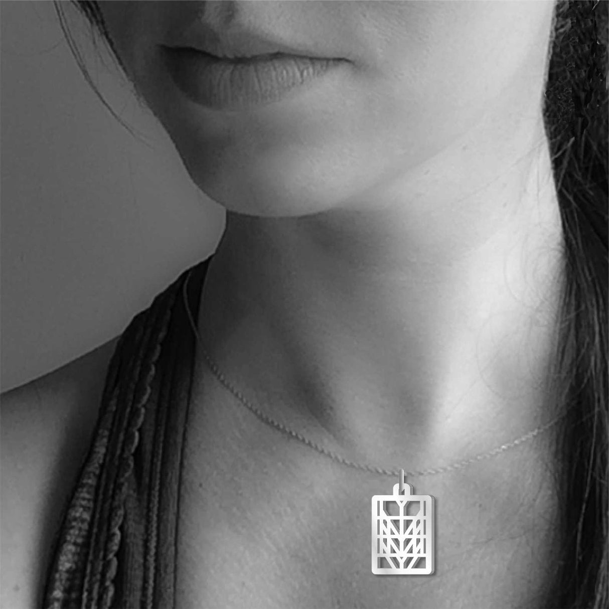 Model wearing the Frank Lloyd Wright Tree of Life Pendant necklace featuring a geometric silver-tone rectangular design.
