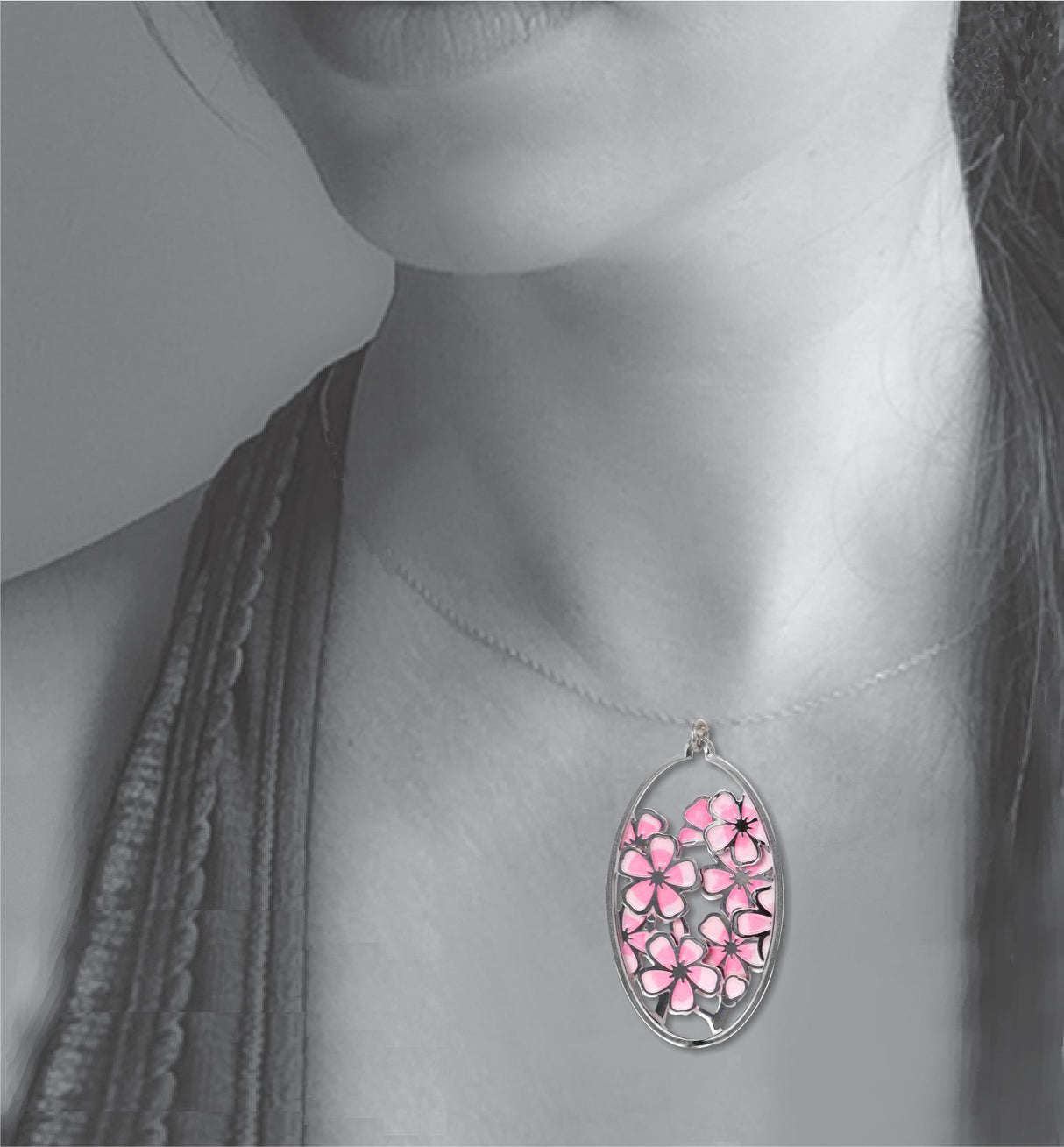 Model wearing the Hiroshige Cherry Blossom pendant necklace featuring an oval silver-tone charm filled with layered pink cherry blossom flowers.