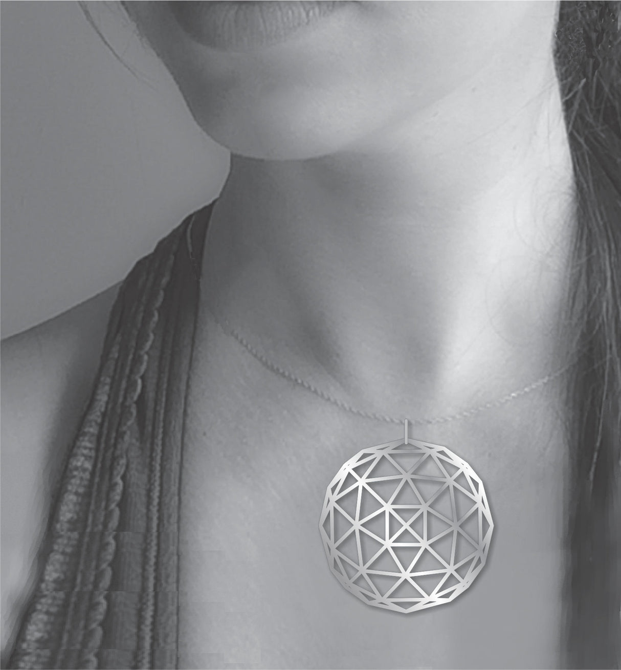 Geodesic Dome necklace shown worn on a model, featuring a large silver-tone geometric pendant with an open triangular dome pattern on a delicate chain.