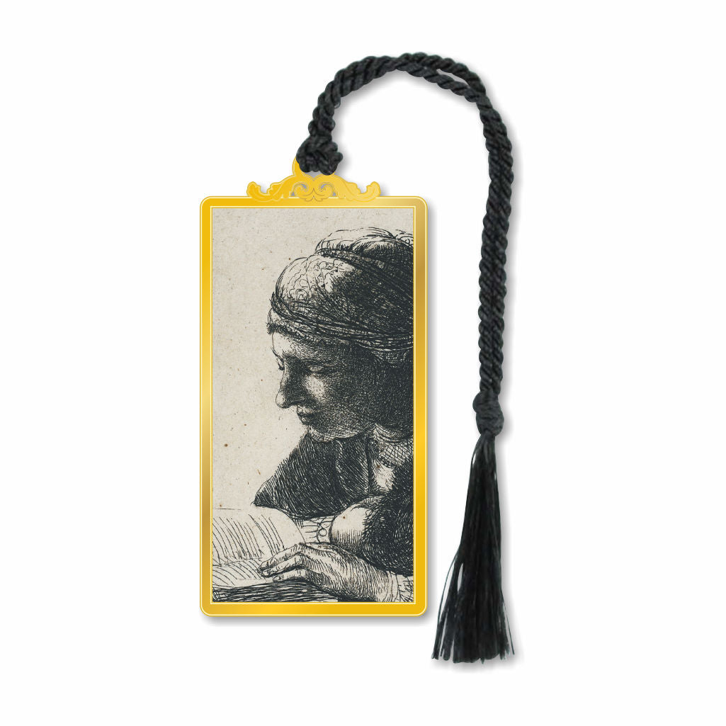 A metal bookmark featuring a gold finish with a black and white print of a person reading, attached to a black braided string tassel.