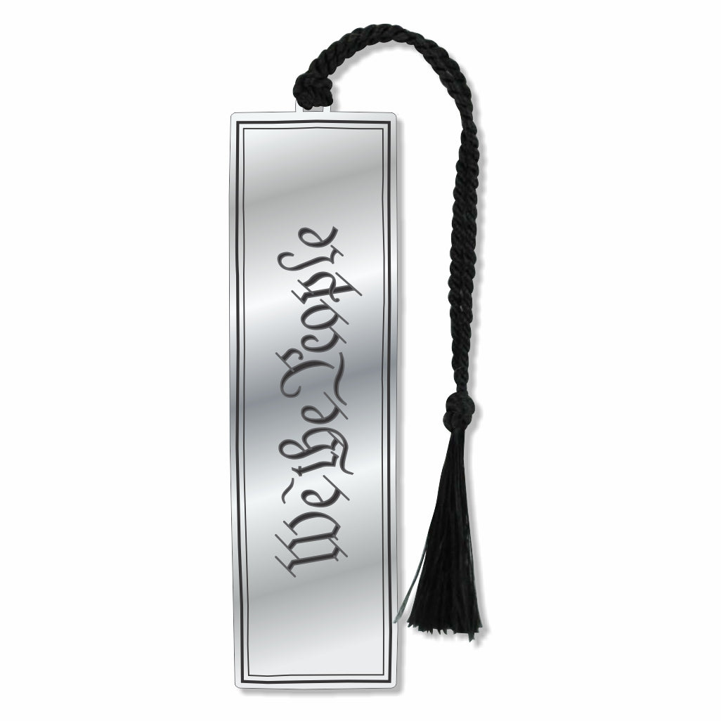 Silver-tone United States Constitution metal bookmark engraved with the word “We The People” in script lettering, featuring a black braided tassel. Celebrating America 250.