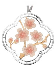 A decorative ornament featuring a floral design with pink cherry blossoms in a circular silhouette, attached to a silver ribbon for hanging for a museum-quality cherry blossom season gift, and art gift.