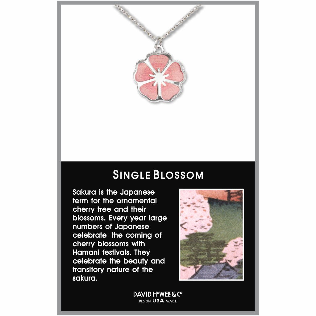 Single Blossom necklace displayed on packaging with a silver-tone flower pendant featuring soft pink petals on a delicate chain, inspired by Japanese cherry blossoms.