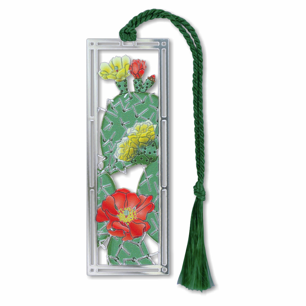 A silver metal bookmark featuring a prickly pear cactus with vibrant flowers, attached to a green tassel.