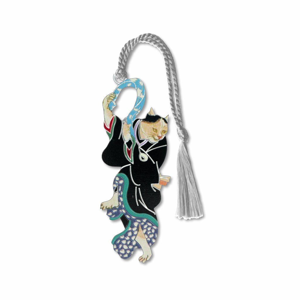 The Dancing Geisha Cat metal bookmark features a stylized illustration of a cat gracefully spinning in an elaborate geisha costume. The design is inspired by the work of Utagawa Kuniyoshi, who often depicted kabuki actors and geishas in animal forms to navigate historical censorship rules in 19th-century Japan. The artwork blends whimsy and tradition, reflecting Edo-period satire and creativity with silver braided tassel.