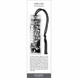 Nine Lives’ bookmark featuring black-and-white cats climbing and lounging on bookshelves, with a black tassel.