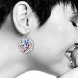Model wearing Spin Art drop earring, featuring a circular design with abstract swirls of red, blue, and gray, creating a bold, modern artistic look.