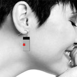 rectangular balance earring with black and red detail on model