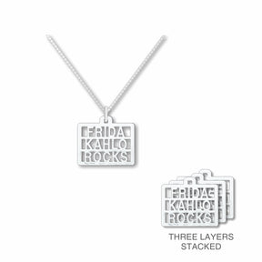Silver necklace with 'Frida Kahlo Rocks' pendant on a white background