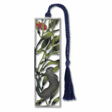 A silver metal bookmark with a design featuring a sea otter, a fish, and kelp forest attached to a blue tassel.