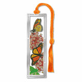 Metal bookmark featuring monarch butterflies with orange-and-black wings and milkweed plants, symbolizing pollinator conservation and habitat restoration for declining monarch populations with orange braided tassel.