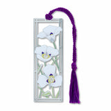 A metal bookmark featuring a detailed image of white to lavender-blue sego lily white petal flowers in a silver frame with a purple tassel.