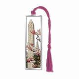 A metal bookmark of Cleopatra's Needle, an obelisk with Empire State building and cherry blossoms with a pink braided tassel.